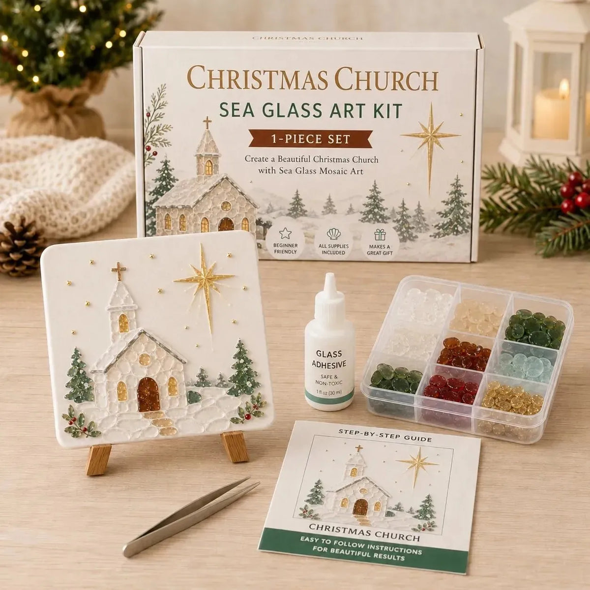 Christmas Church Sea Glass Art Kit 1-piece set displayed on a wooden table with its box, finished artwork piece on a small easel, glass adhesive bottle, multi-compartment tray of sea glass beads, tweezers, and an instruction booklet.