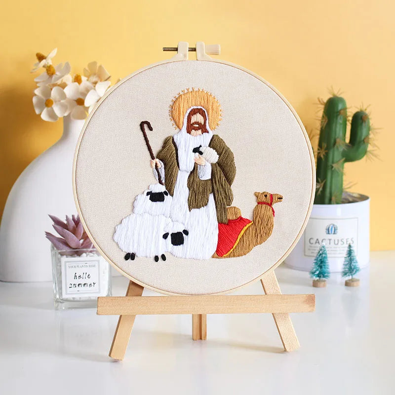 Embroidery hoop with a religious figure design with a man, sheep, and camel