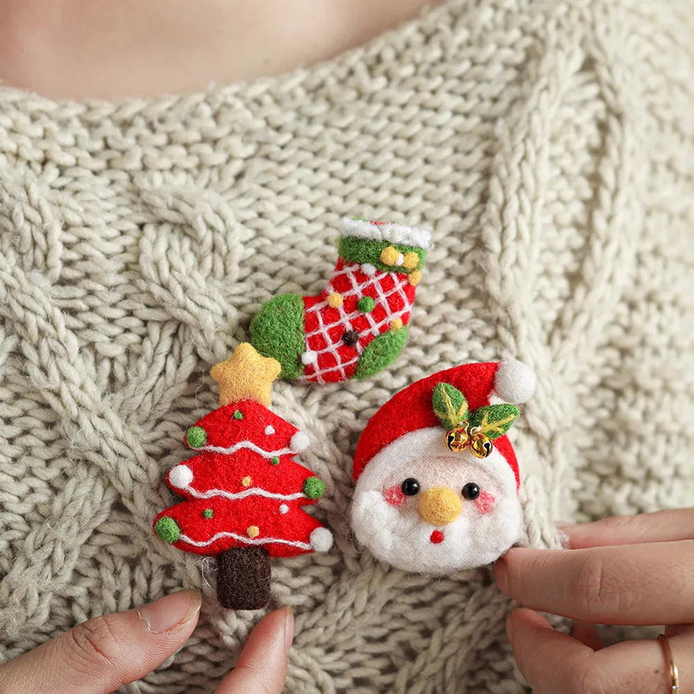 Three needle felted brooches, a Christmas stocking, tree, and Santa.