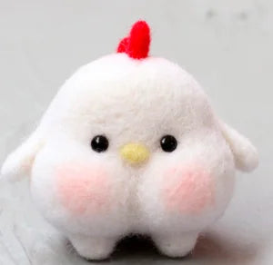 A cute, fluffy white needle felted toy shaped like a chicken, featuring a small red comb on top, a yellow beak, pink cheeks, and black bead eyes.