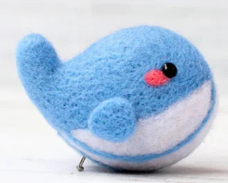 A blue and white need felted whale 