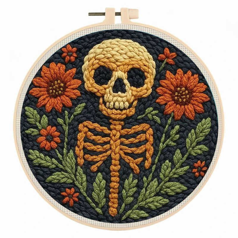 Embroidery hoop with a skeleton and floral punch needle design on a dark background