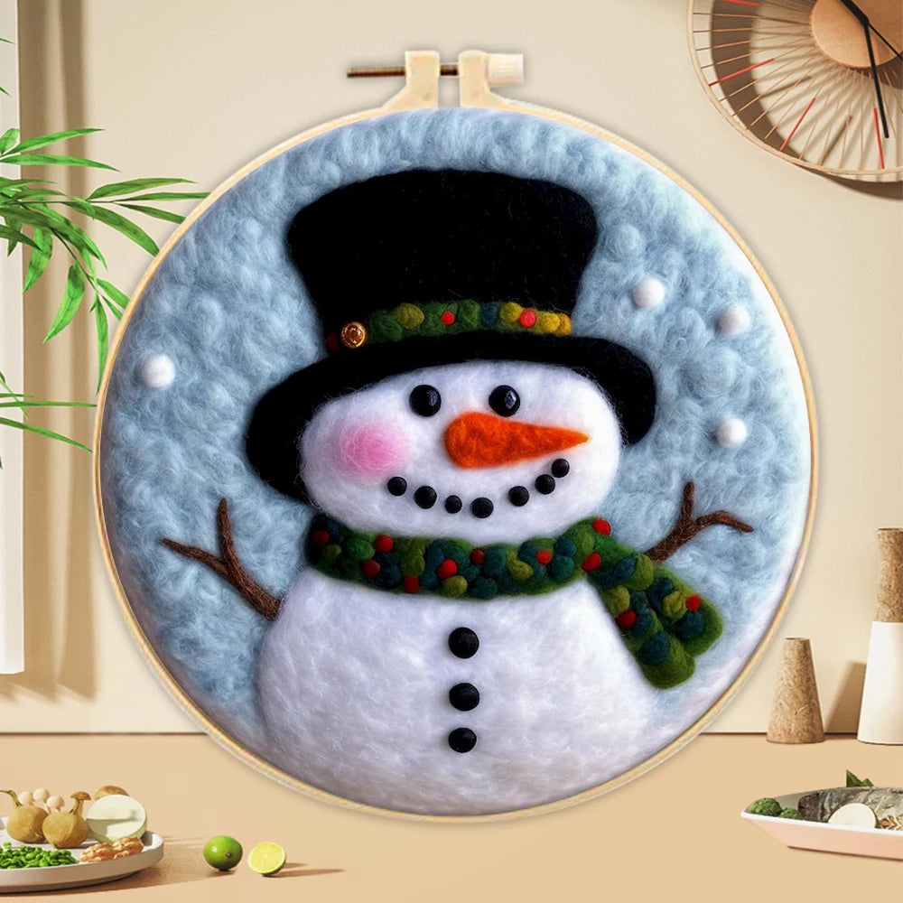 Wool needle felted snowman portrait with a black hat, carrot nose, green scarf and black eyes on a light blue background