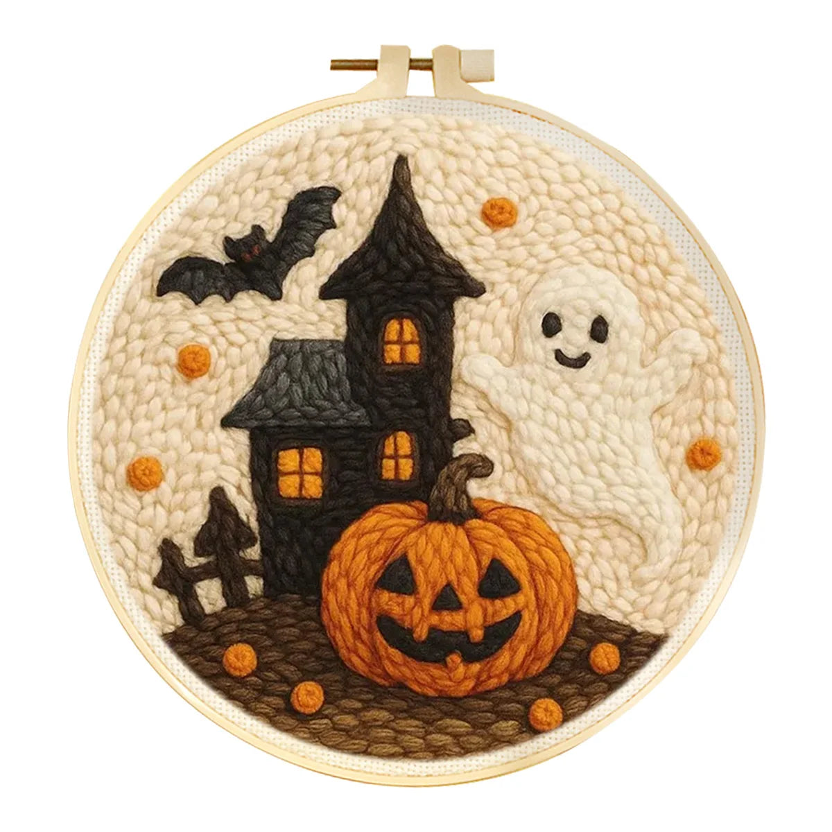 Embroidery hoop with Halloween-themed punch needle design featuring a haunted house, pumpkin, and ghost.