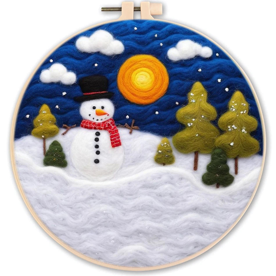 Needle felted full moon, starry night scene with white clouds, a snowman wearing a black hat and red scarf and 6 trees all on a snowy hillside.
