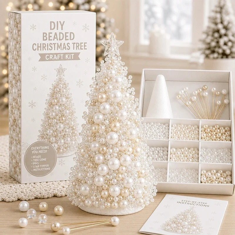 DIY Beaded Christmas Tree Craft Kit shown with its white packaging box, a completed white pearl-beaded Christmas tree, an open tray of beads and gold-tone wire picks, and instruction cards on a tabletop.