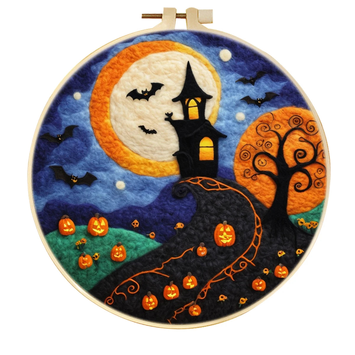 A circular needle felted style Halloween scene with a large cream moon, blue night sky, black haunted house, orange tree, bats, pumpkins, and a winding hill with small orange figures
