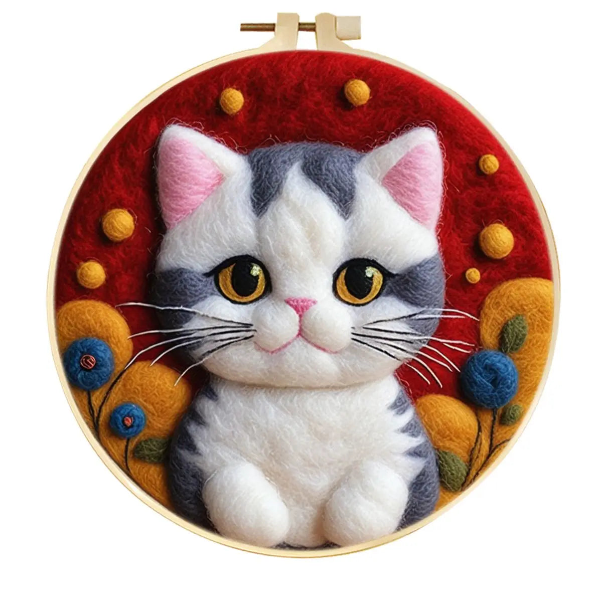 A circular needle felted art piece featuring a gray and white cat with yellow eyes, set against a red background with orange and blue floral accents, displayed in a wooden hoop 