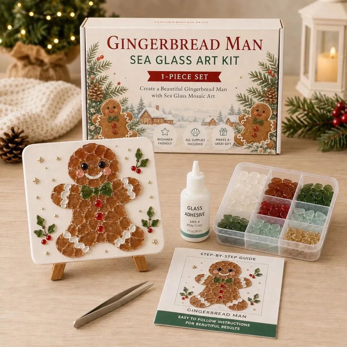 Gingerbread Man Sea Glass Art Kit 1-piece set displayed on a wooden table, including the product box, a finished gingerbread man mosaic piece on a small easel, a bottle of glass adhesive, a tray of colorful sea glass beads, tweezers, and a step-by-step guide.