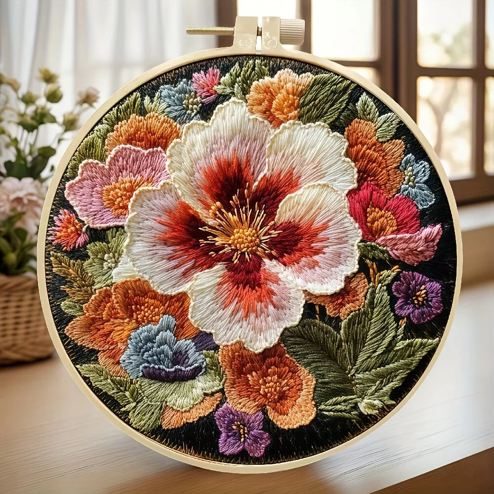 Embroidered floral design in a wooden hoop on a light surface.