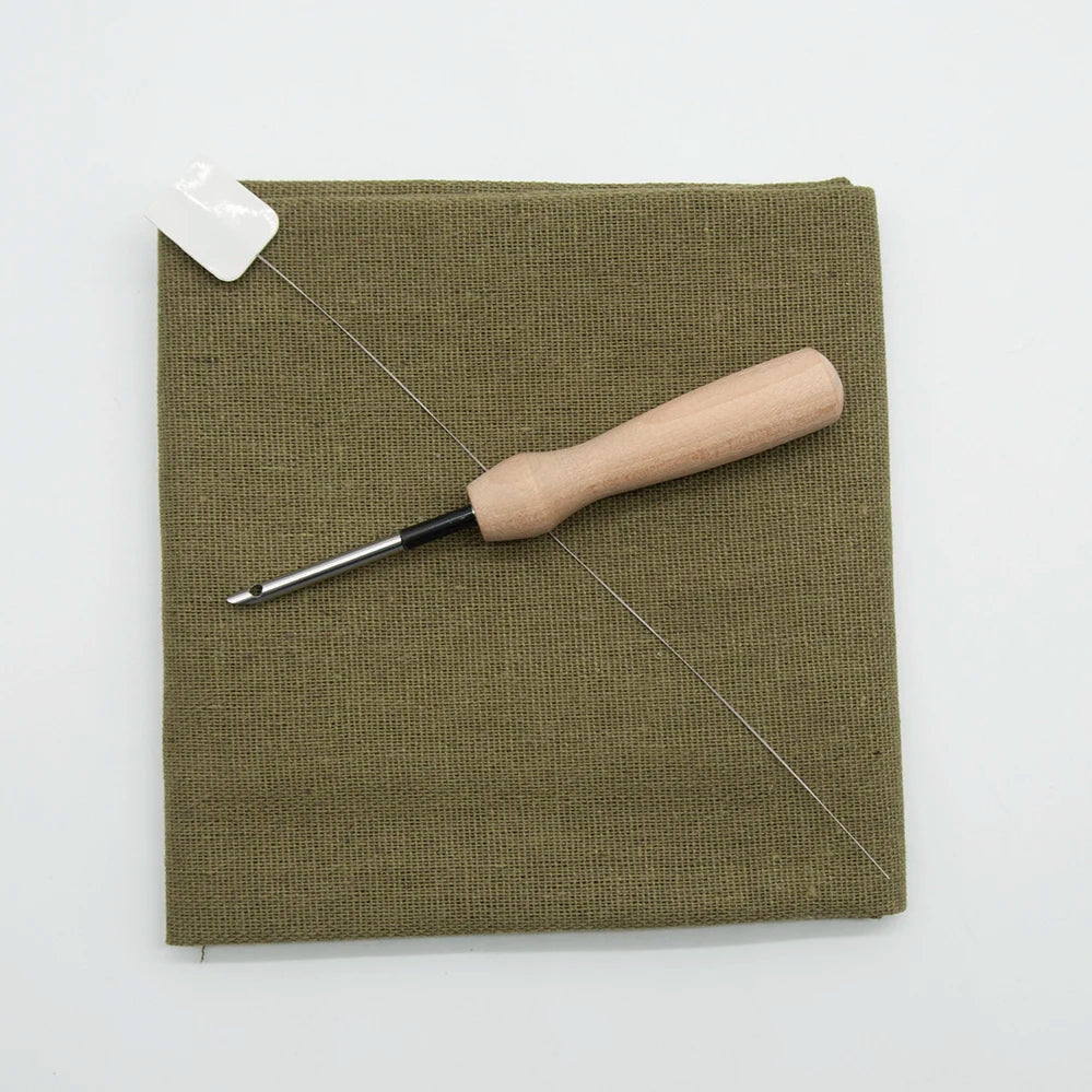 Green fabric square with a wooden tool on a white background