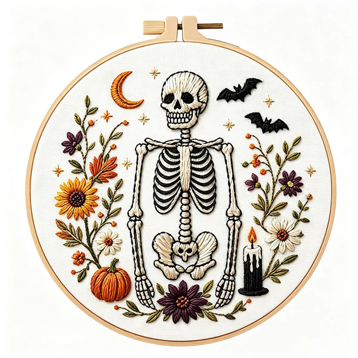 A circular embroidery hoop displays a Halloween-themed embroidery design on white fabric. The design features a black-and-white skeleton, orange pumpkins, purple and yellow flowers, black bats, a crescent moon, and a black candle.