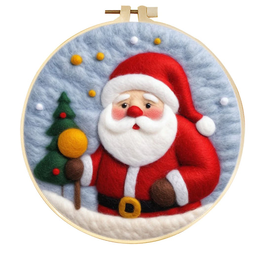 Needle felted Santa with a blue background, an evergreen tree, some baubles in a hoop frame.