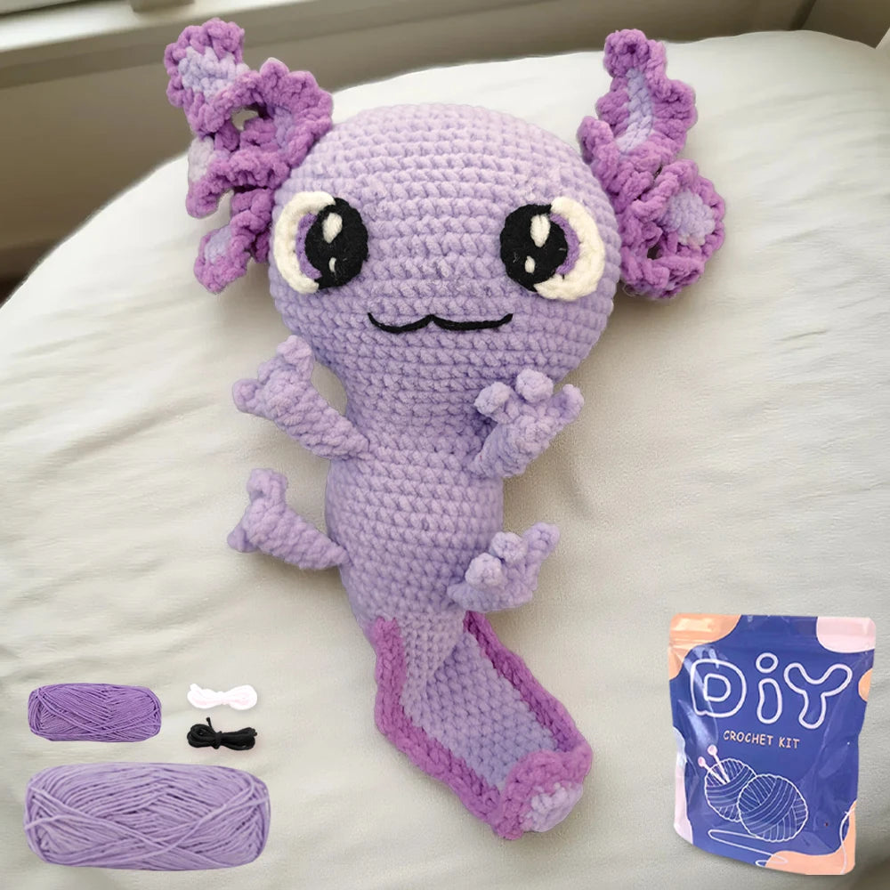 Crocheted purple salamander with flower-like appendages , accompanied by a DIY crochet kit bag.