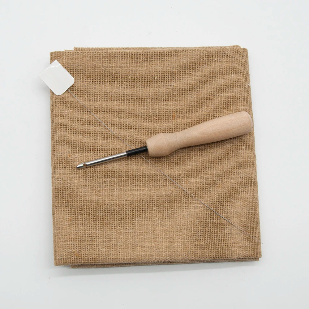 Light brown textured fabric with a wooden tool on a white background