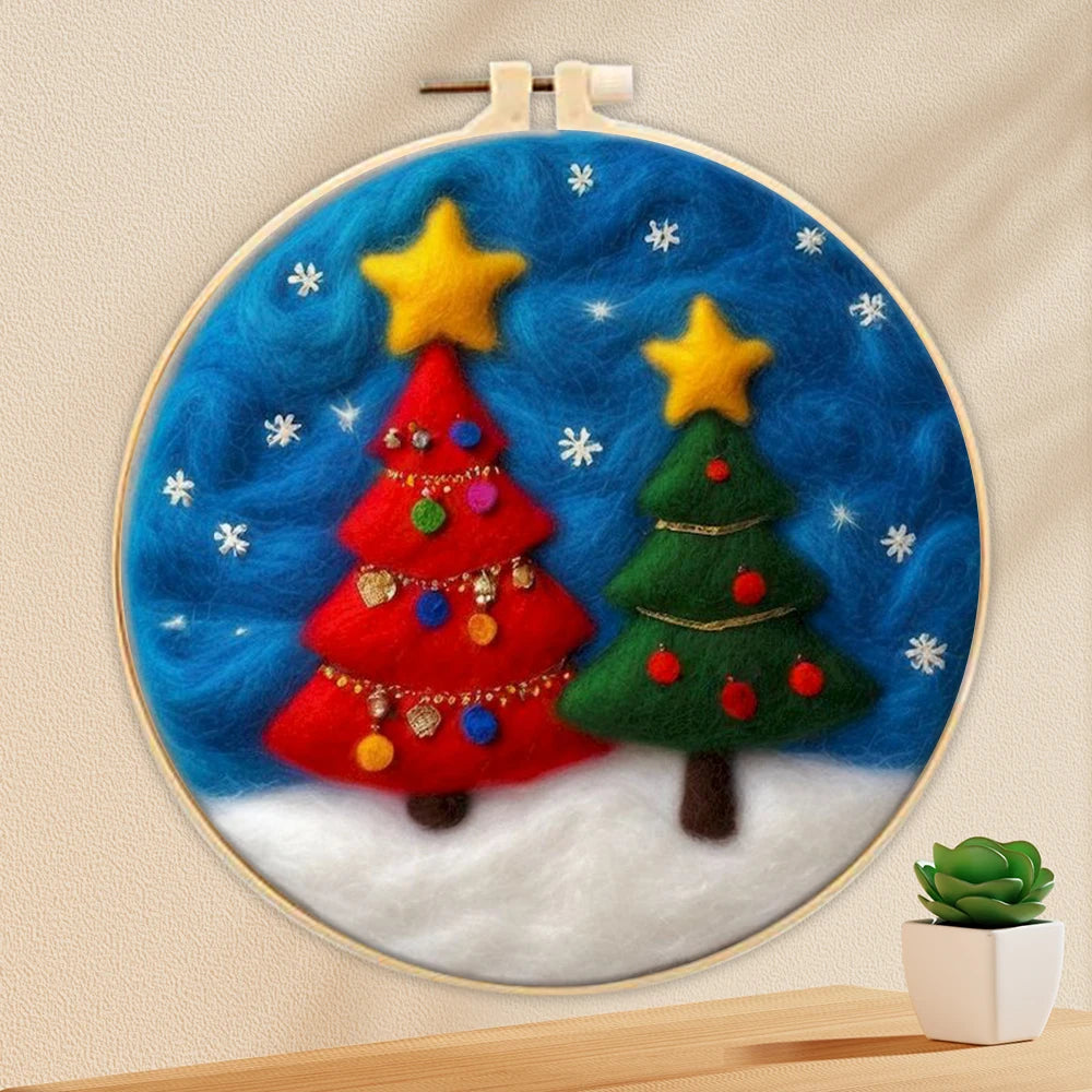 Two wool needle felted Christmas trees,one red and the othe green with gold stars on tops, blue night sky and white stars