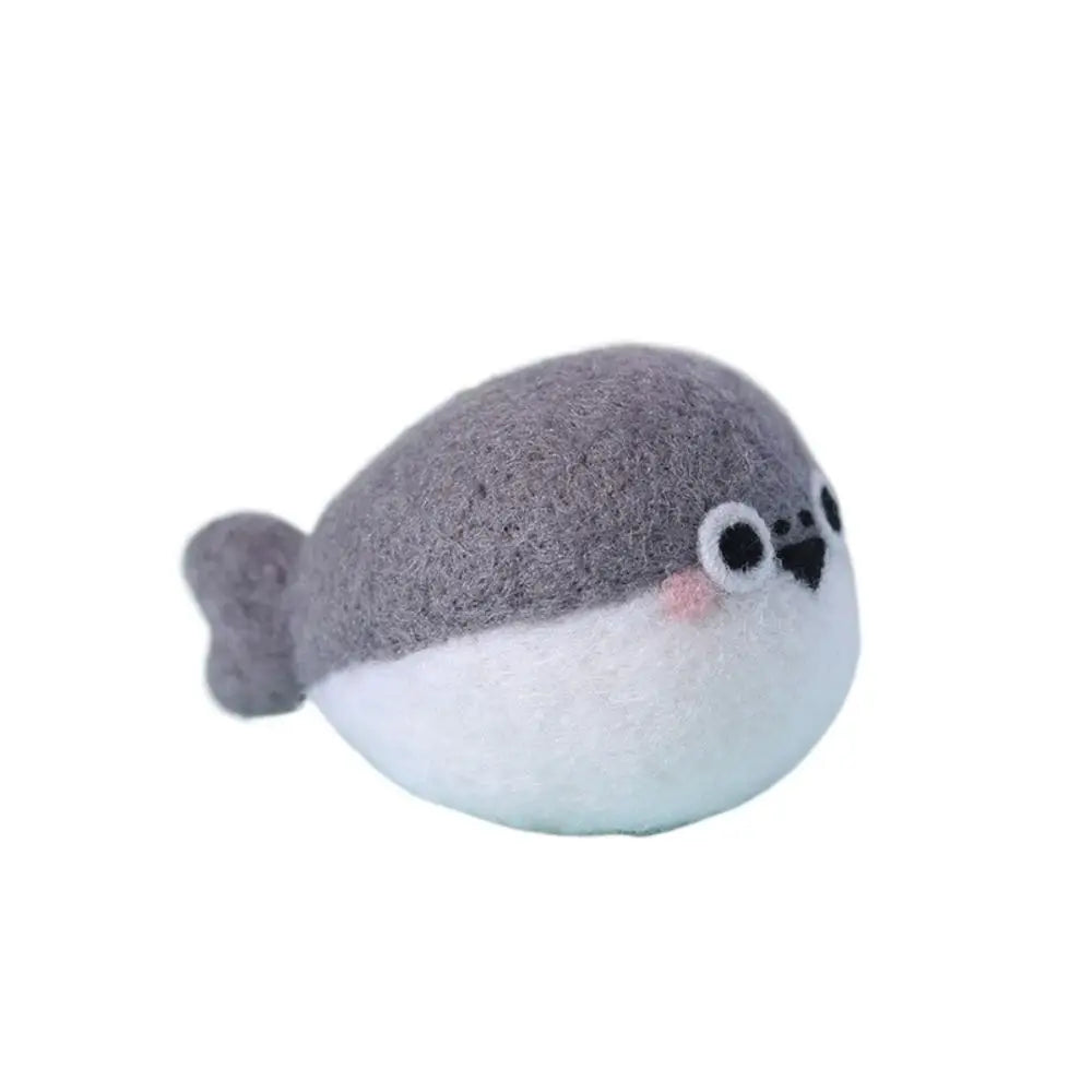 Needle felted whale with gray top and white bottom on a white background