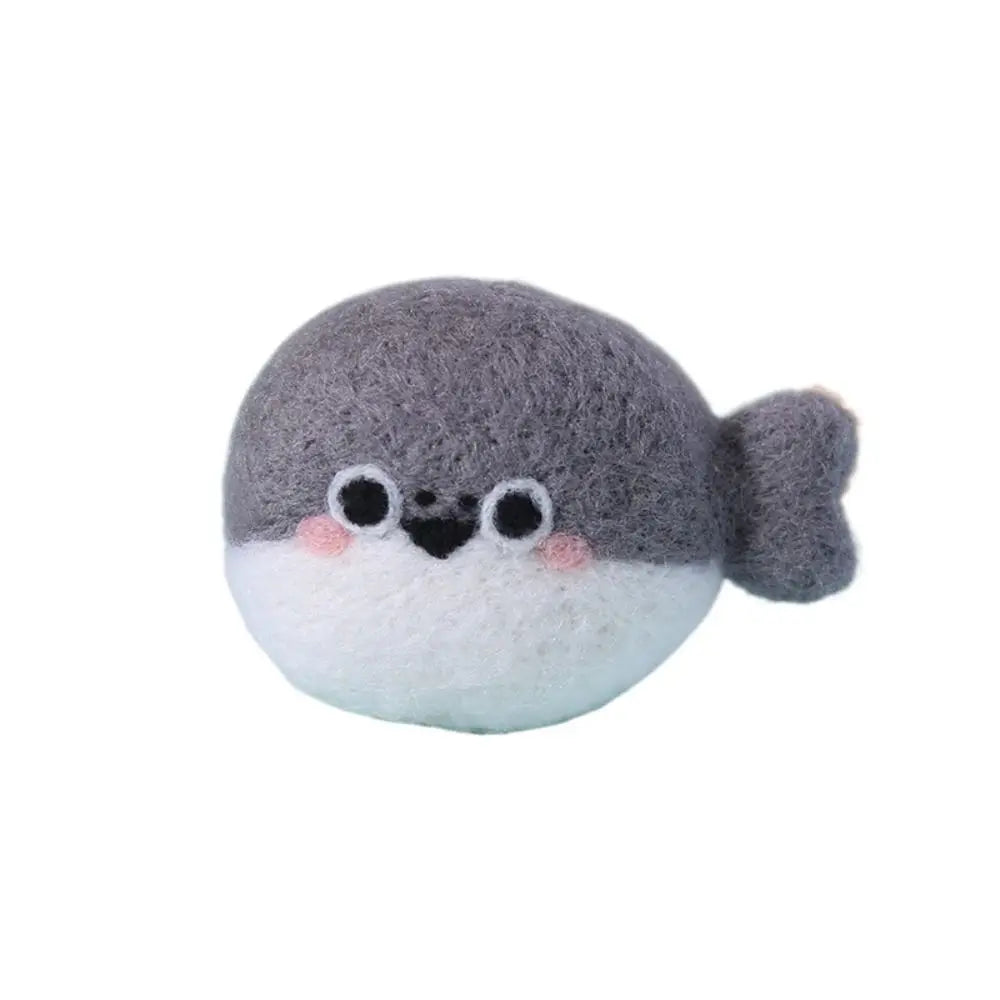 Needle felted whale with a gray top and white bottom on a white background  