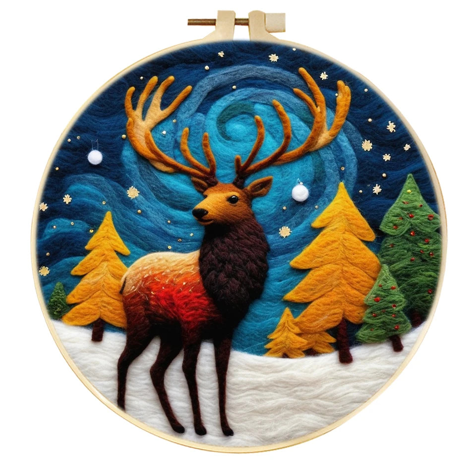 Needle felted winter night scene with a reindeer, snow on the ground, 5 trees, snowflakes and blue swirls that look like the northern lights. 