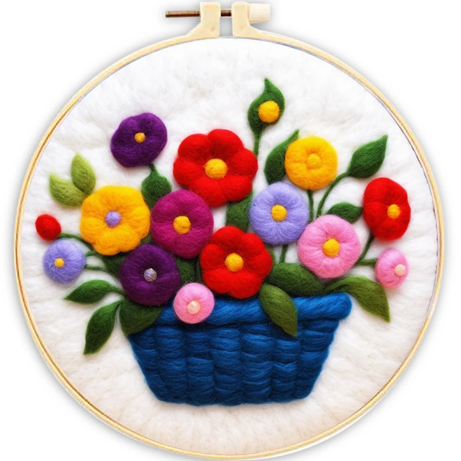 Embroidery hoop with colorful flowers in a blue basket on a white background