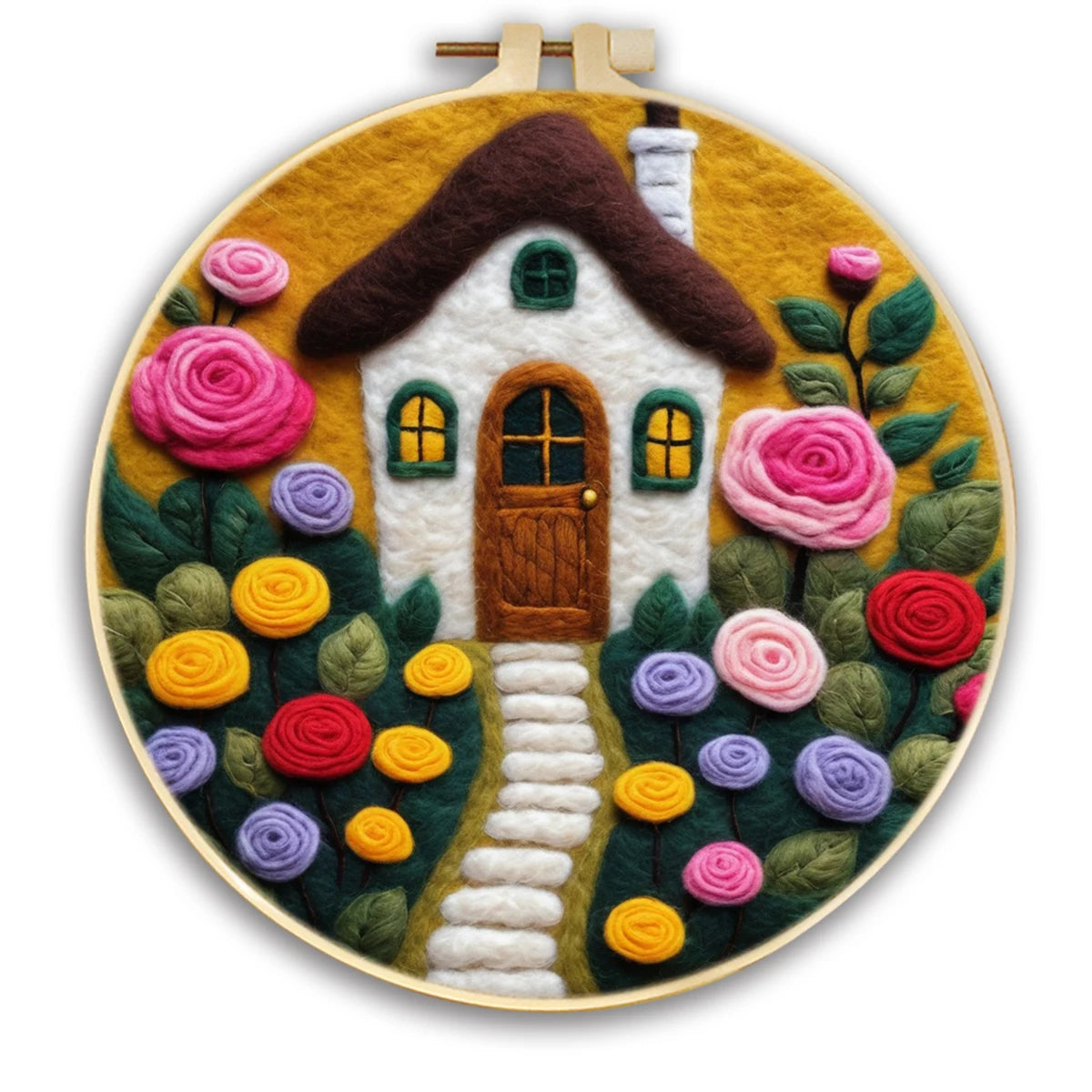 A circular hoop featuring a handmade needle felted cottage scene with a white house, brown roof, pink. purple, yellow  and red roses, green leaves, and a winding white path on a mustard yellow background.