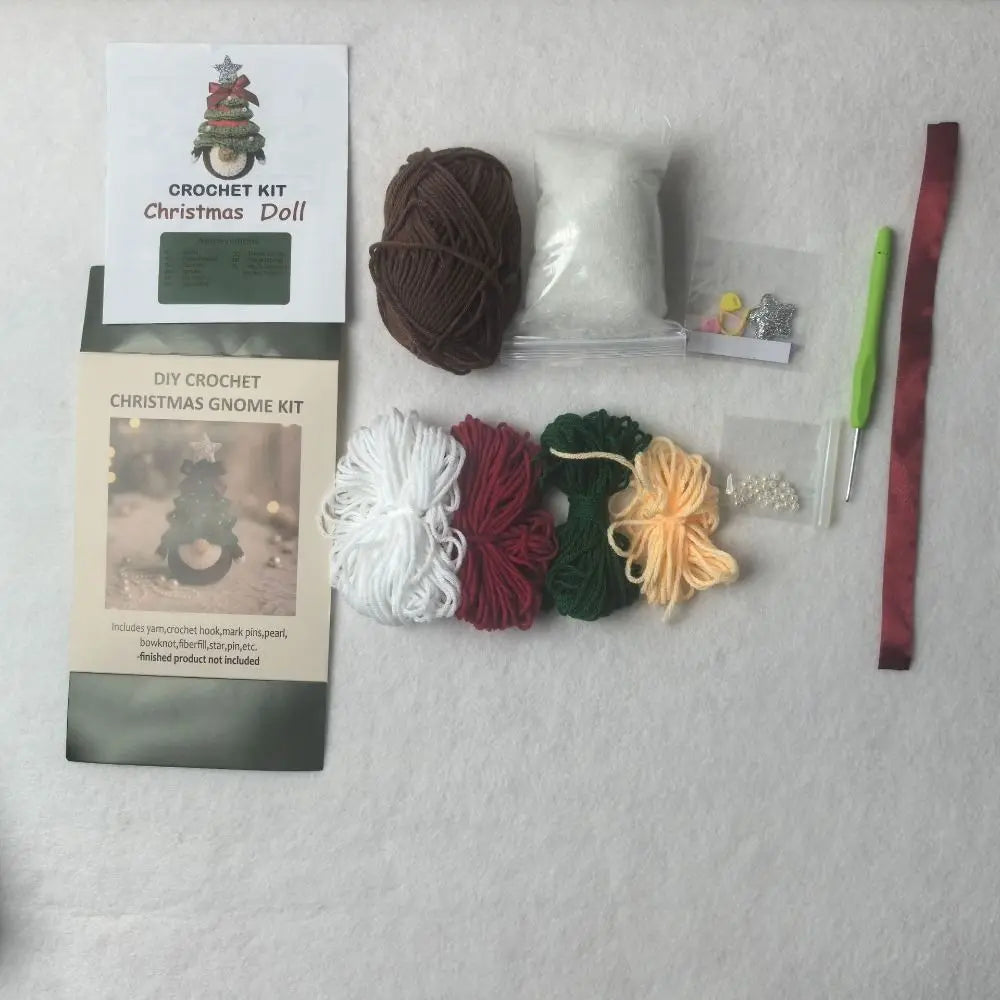 DIY crochet Christmas gnome kit laid out on a white textured background, including a crochet doll pattern card, yarn balls in brown, white, burgundy, green, and pale yellow, a green-handled crochet hook, ribbon, beads, and small accessories.
