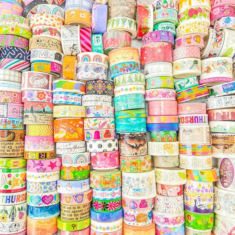 Stack of colorful washi tape rolls with various designs