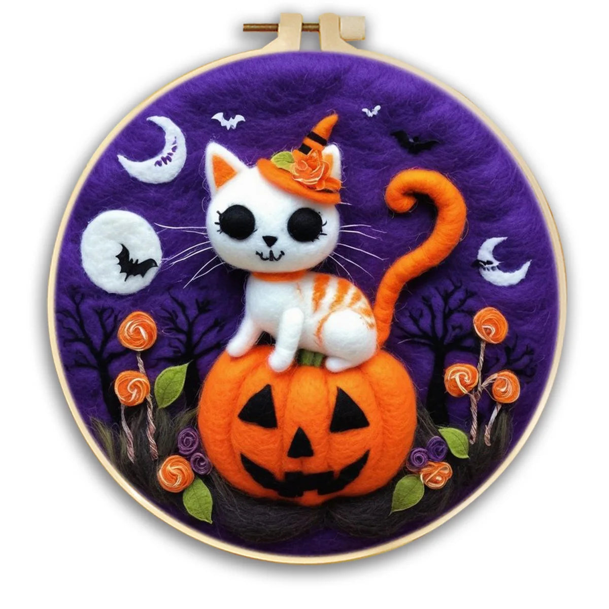 Embroidery hoop with a Halloween-themed needle felting design featuring a white tiger cat on a pumpkin, bats, moons & flowers.