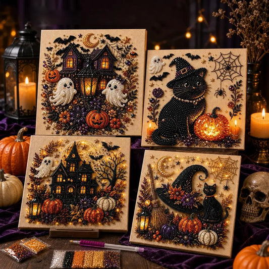 Three square Halloween-themed beaded wall art panels displayed on a dark table with candles, pumpkins, and decorative props. The designs feature a haunted house, a black cat in a witch hat, and a witch broom, all embellished with black, orange, purple, white, and gold beads, with small LED lights embedded in the pieces.