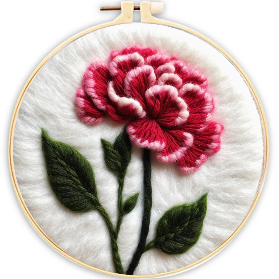Embroidery hoop with a pink flower and green leaves on a white background