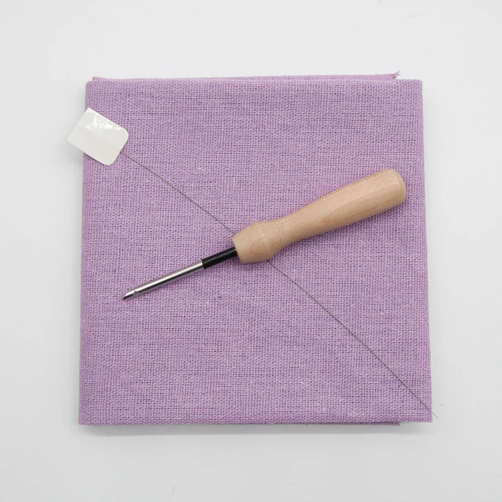 Purple fabric with a wooden tool on a white background
