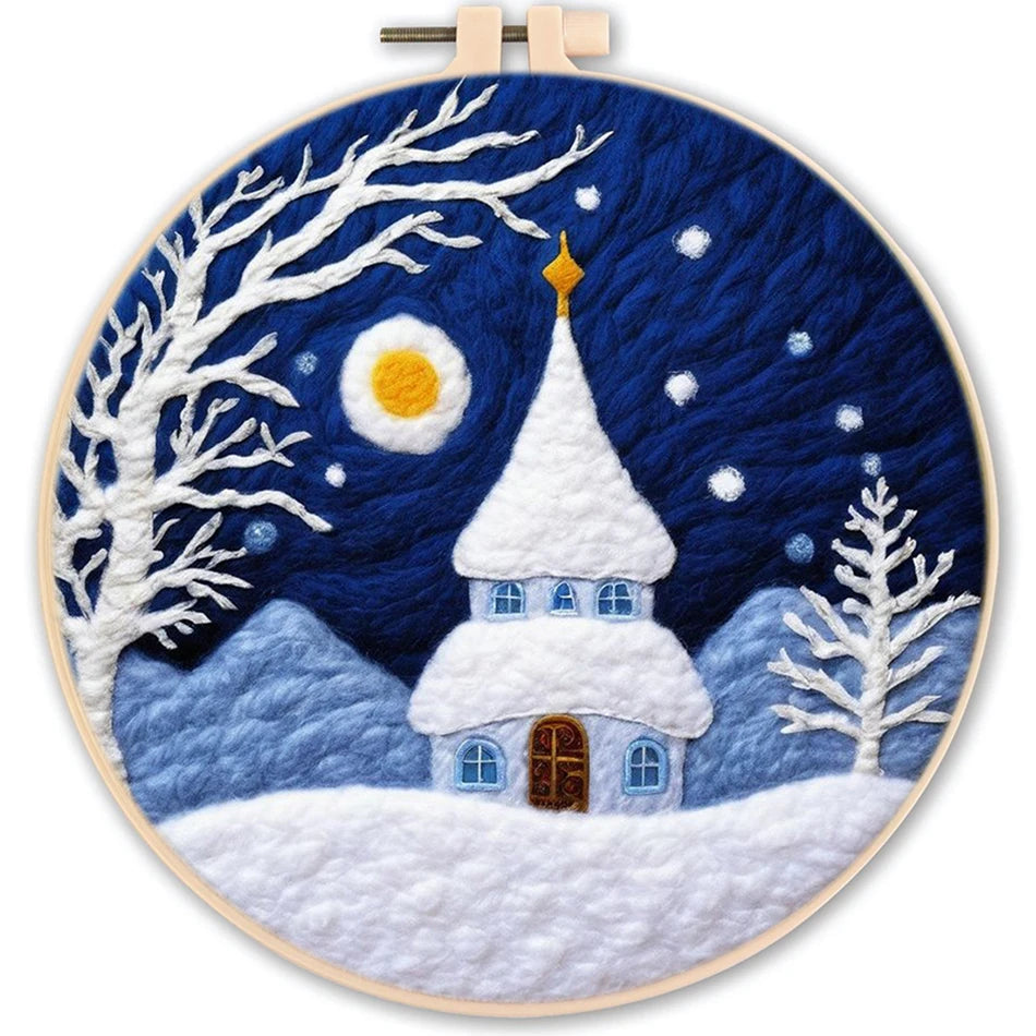 Needle felted winter scene with a full moon, mountains in the background, a dark sky with stars, a snow covered church and snow covered trees and snow on the ground