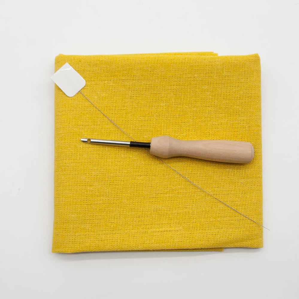 Yellow fabric with a punch needle on a white background