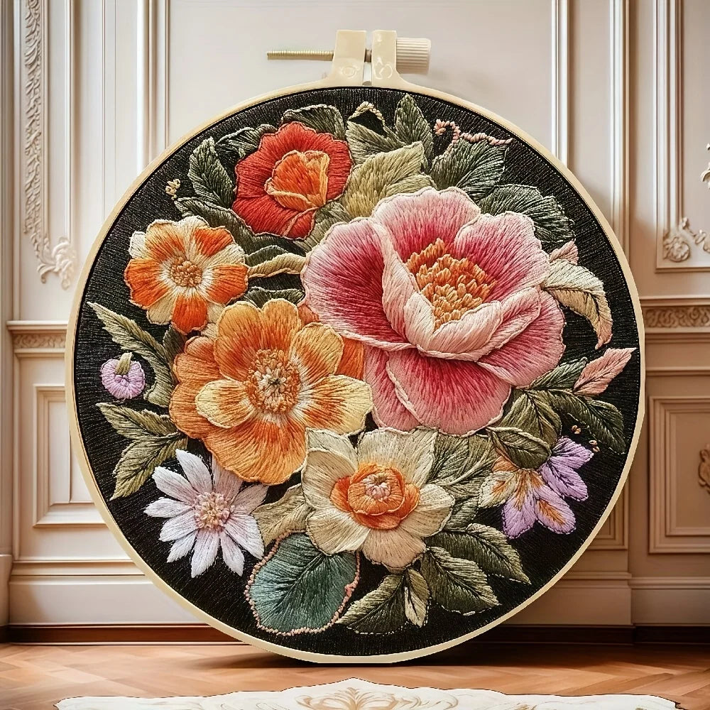 Embroidered floral design on a black background in an embroidery hoop, set against a decorative wall.