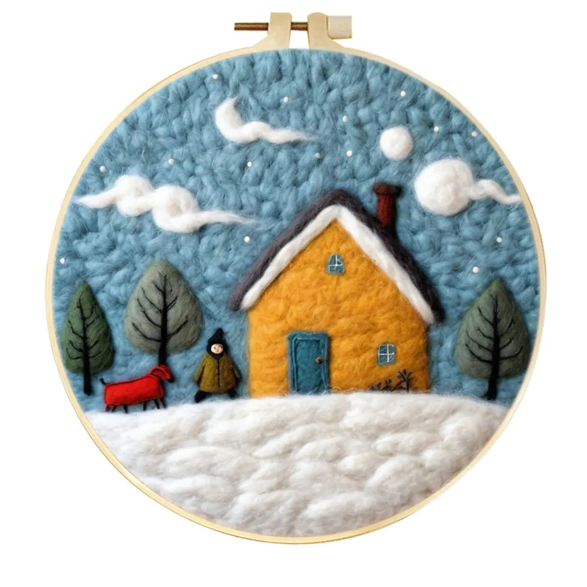 A circular needle felting winter scene in an embroidery hoop featuring  a yellow house, snowy ground, blue sky, trees, clouds, a person, trees, and a small red dog