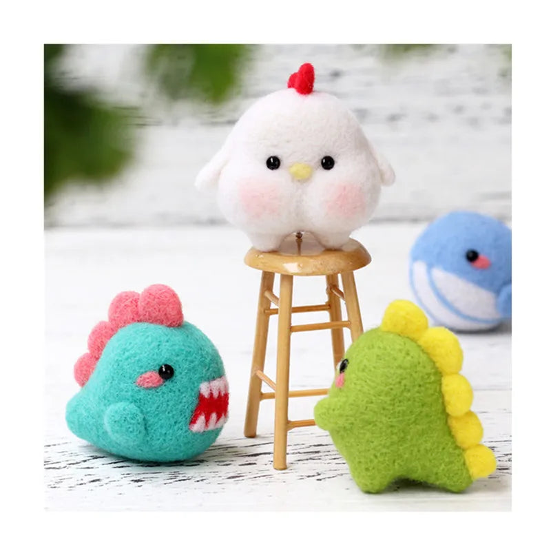 Three cute handcrafted needle felted plush toys: a white chicken sitting on a small wooden stool with a red comb, a turquoise dinosaur with pink spikes and open teeth, and a green dinosaur with yellow spikes. A blurred blue plush toy appears in the background.