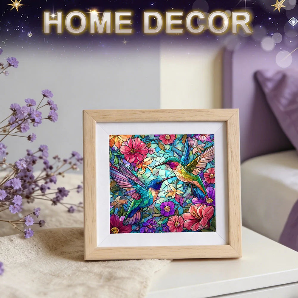 A framed colorful artwork featuring two hummingbirds and vivid flowers. The words 'HOME DECOR' appear at the top.